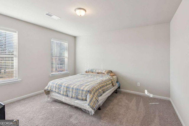 carpeted bedroom with multiple windows