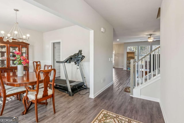 dining room with ceiling fan with notable chandelier and dark hardwood / wood-style flooring