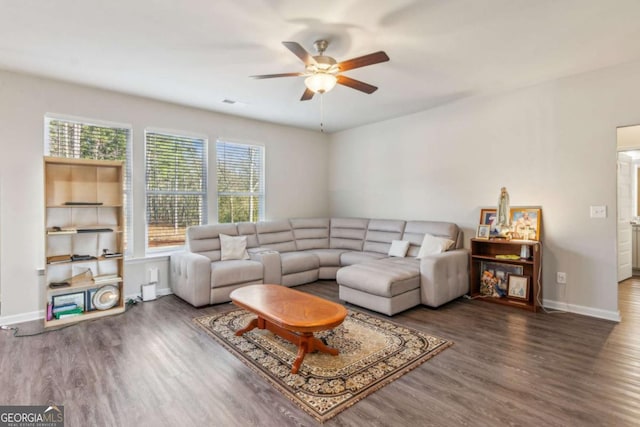 living room with ceiling fan and dark wood-type flooring