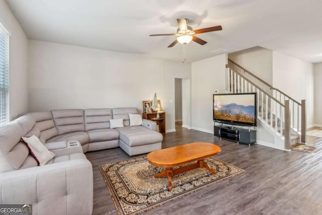 living room with ceiling fan and dark wood-type flooring