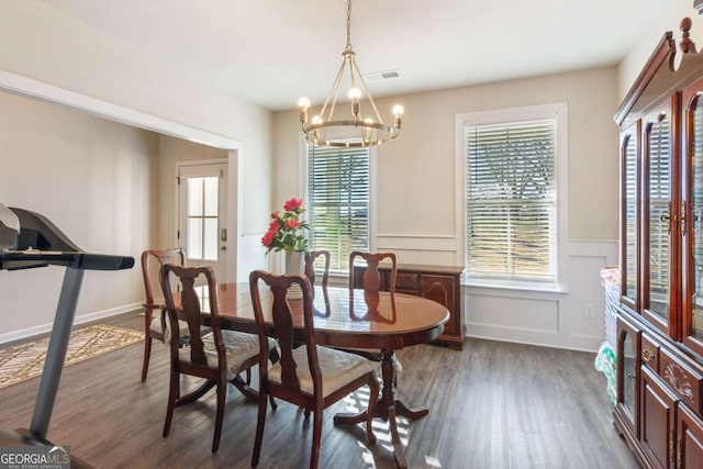 dining area featuring dark hardwood / wood-style flooring, an inviting chandelier, and plenty of natural light