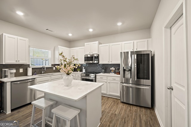 kitchen featuring a kitchen island, sink, white cabinets, and stainless steel appliances