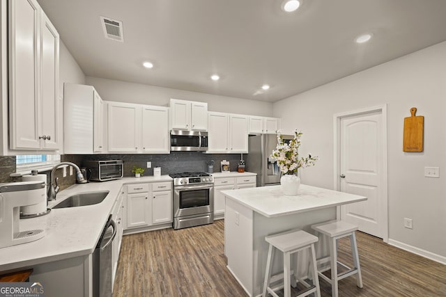 kitchen featuring a kitchen island, white cabinets, sink, and stainless steel appliances