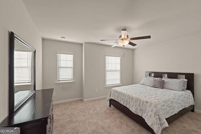 carpeted bedroom featuring multiple windows and ceiling fan