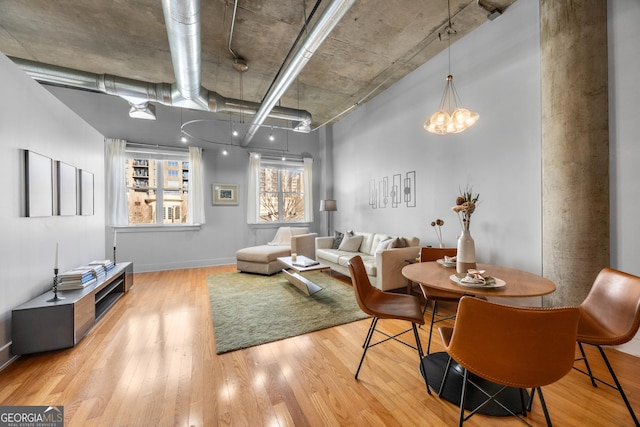 living room featuring a notable chandelier and light hardwood / wood-style flooring