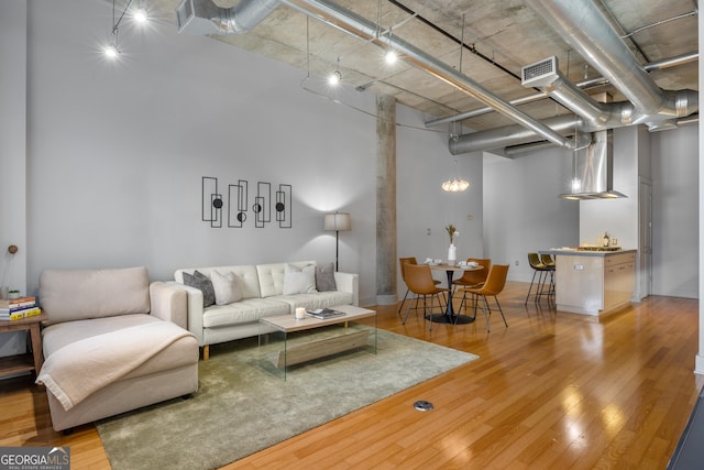 living room featuring a towering ceiling and wood-type flooring