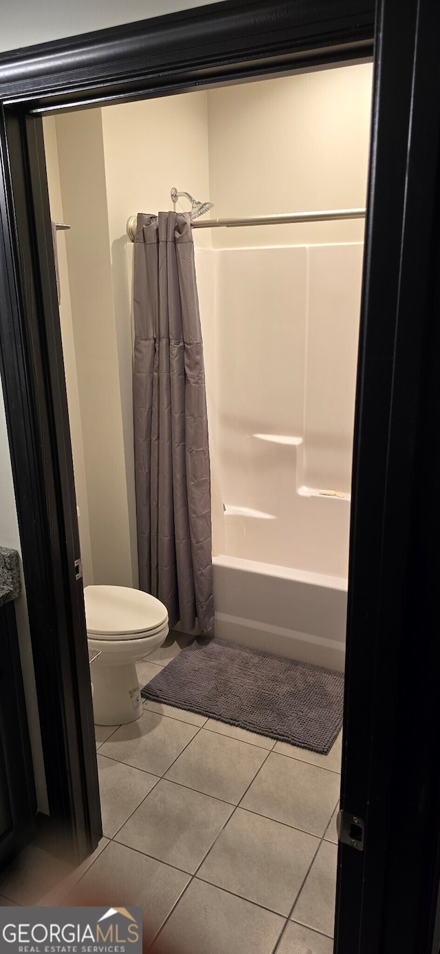 full bathroom with toilet, shower / tub combo, and tile patterned floors