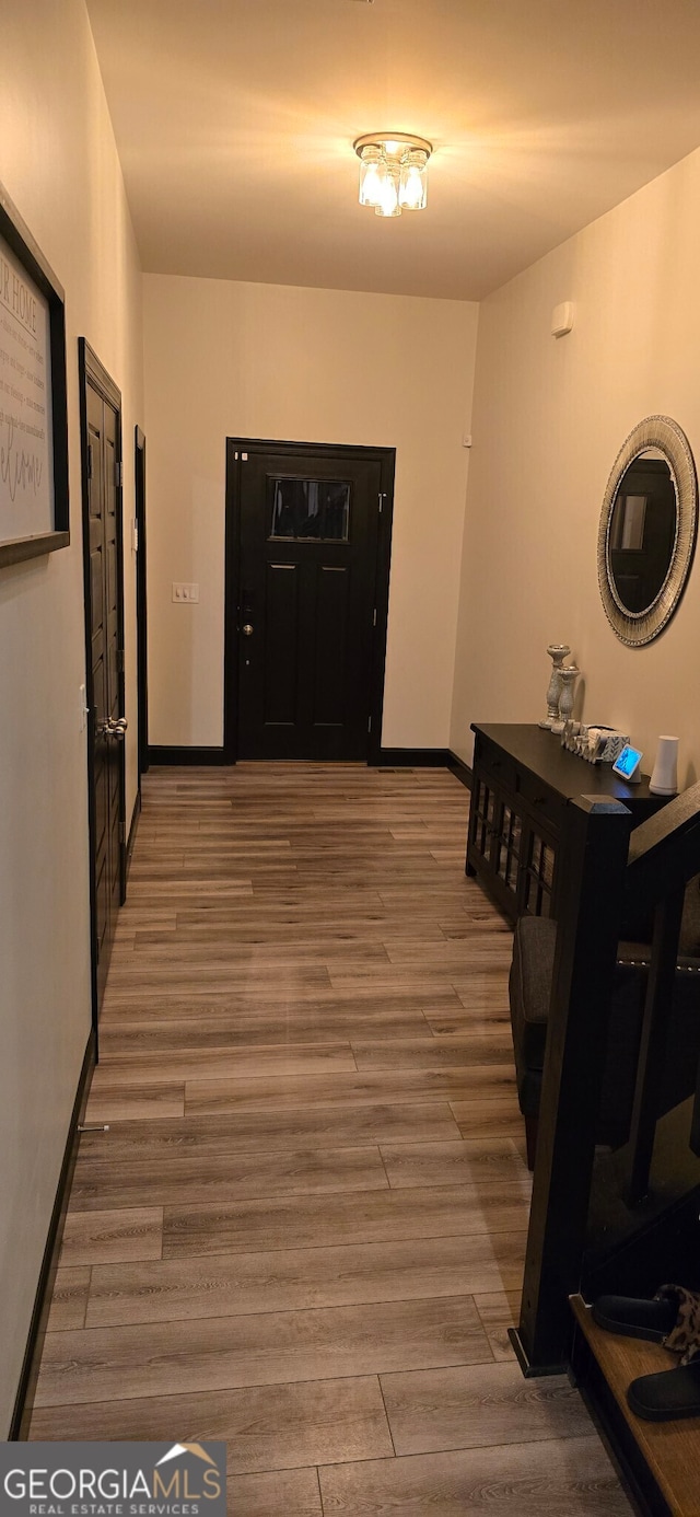 hallway featuring baseboards and wood finished floors