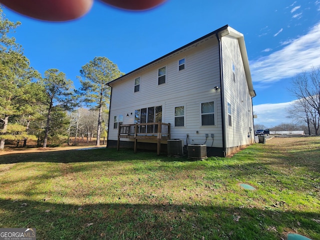 rear view of house with central AC, a yard, and a wooden deck