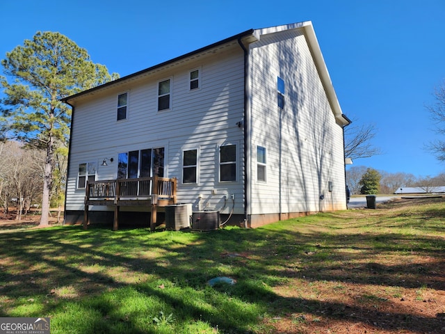 rear view of property featuring cooling unit, a lawn, and a deck