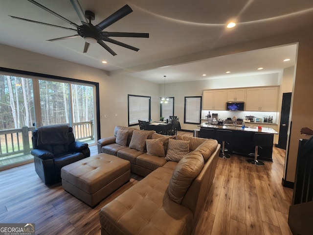 living room featuring ceiling fan and light wood-type flooring