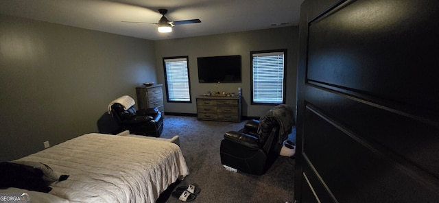 bedroom featuring dark carpet, a ceiling fan, and baseboards