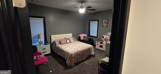 bedroom with a ceiling fan and dark carpet