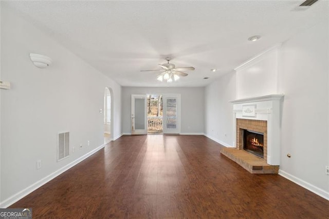 unfurnished living room featuring ceiling fan, dark hardwood / wood-style floors, and a fireplace