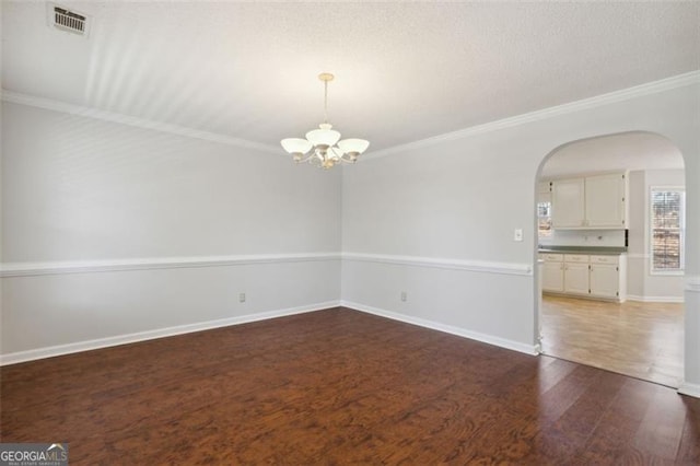 unfurnished room with dark hardwood / wood-style flooring, a chandelier, and ornamental molding