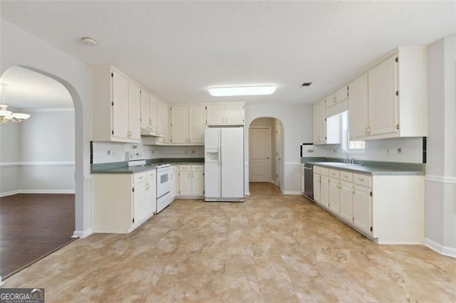 kitchen featuring white appliances, sink, tasteful backsplash, and white cabinetry