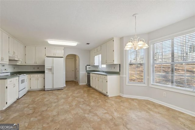 kitchen with white appliances, decorative light fixtures, a notable chandelier, white cabinetry, and sink