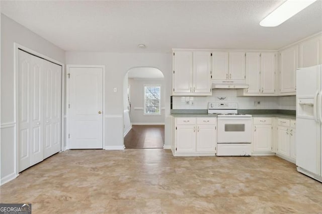 kitchen with white appliances, decorative backsplash, and white cabinets