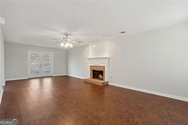 unfurnished living room featuring ceiling fan and dark wood-type flooring