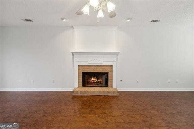 unfurnished living room with ceiling fan, dark hardwood / wood-style flooring, and a fireplace