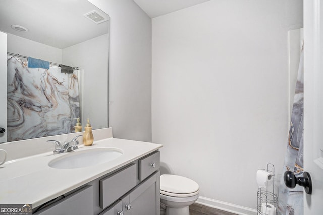 bathroom featuring toilet, hardwood / wood-style flooring, and vanity