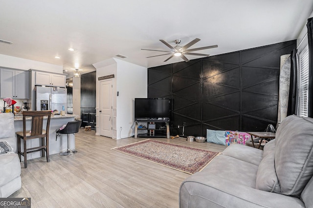 living room featuring light hardwood / wood-style floors and ceiling fan