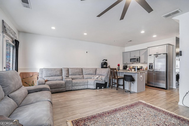 living room with ceiling fan and light hardwood / wood-style floors