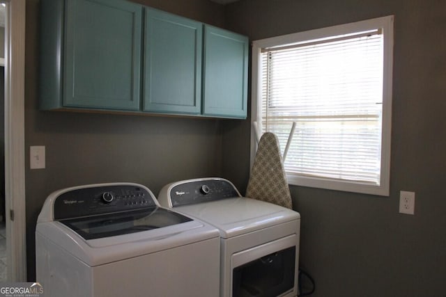 clothes washing area featuring independent washer and dryer and cabinets