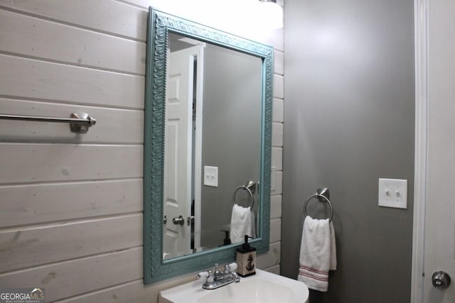 bathroom with sink and wooden walls