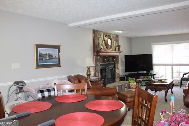 dining space featuring a textured ceiling, carpet, beamed ceiling, and a fireplace