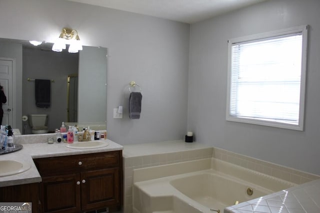 bathroom with plenty of natural light, toilet, vanity, and a bathing tub