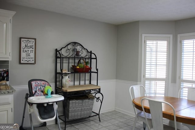 tiled dining room featuring a textured ceiling