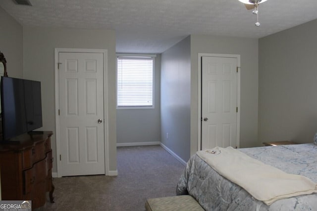 bedroom with carpet floors, ceiling fan, and a textured ceiling