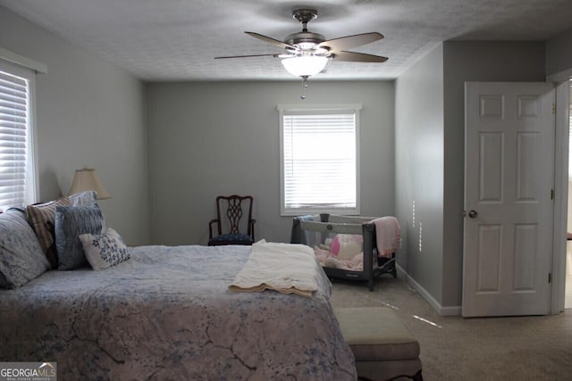 bedroom with a textured ceiling, ceiling fan, and light colored carpet