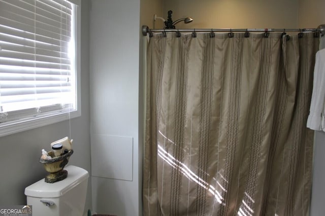 bathroom with walk in shower and toilet