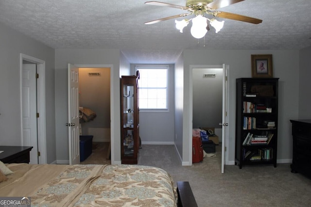 carpeted bedroom featuring ceiling fan, a textured ceiling, a spacious closet, and a closet