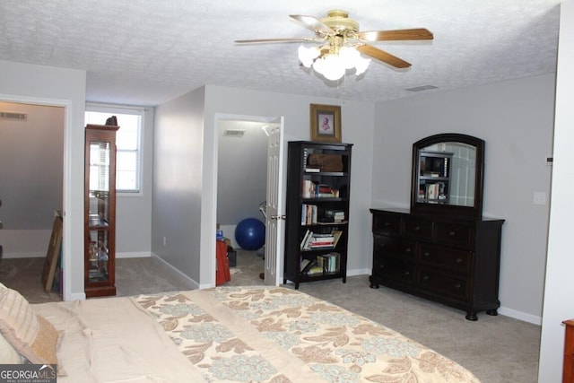 bedroom featuring a textured ceiling, ceiling fan, and light colored carpet