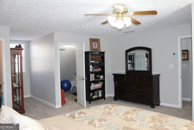 carpeted bedroom featuring a textured ceiling and ceiling fan