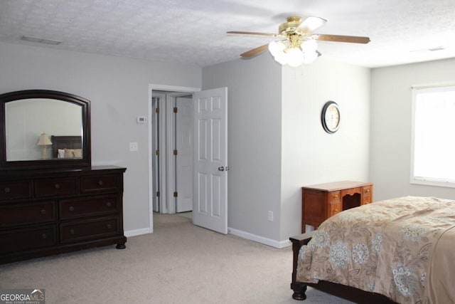 bedroom featuring ceiling fan, a textured ceiling, and light carpet