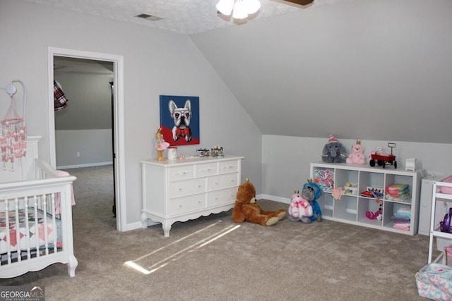 carpeted bedroom with a textured ceiling, ceiling fan, lofted ceiling, and a crib