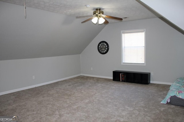 additional living space with a textured ceiling, ceiling fan, lofted ceiling, and carpet floors