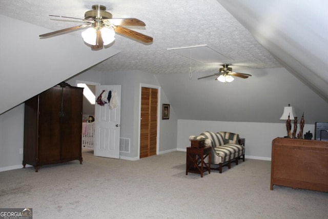 unfurnished bedroom with ceiling fan, light colored carpet, and a textured ceiling