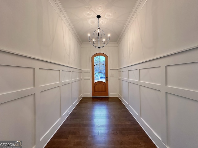 entryway featuring dark hardwood / wood-style flooring, a notable chandelier, and crown molding