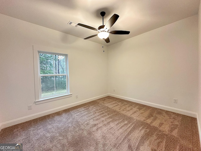 carpeted spare room featuring ceiling fan