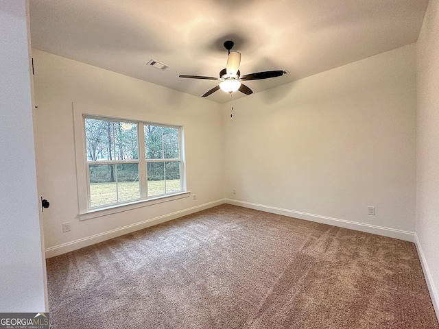 spare room featuring ceiling fan and carpet