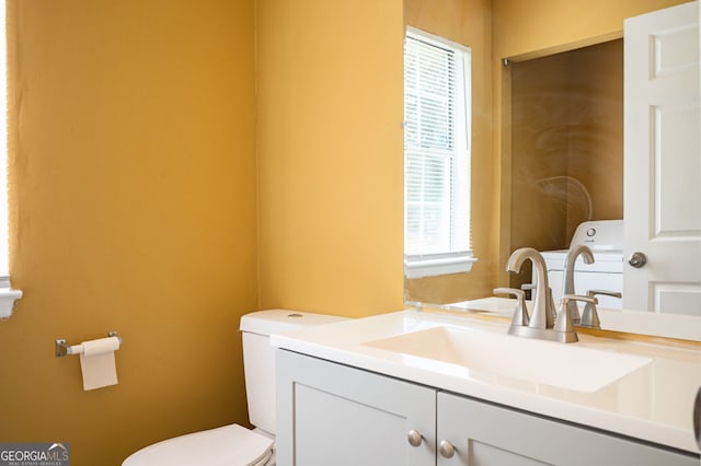 bathroom with washer / dryer, vanity, and toilet