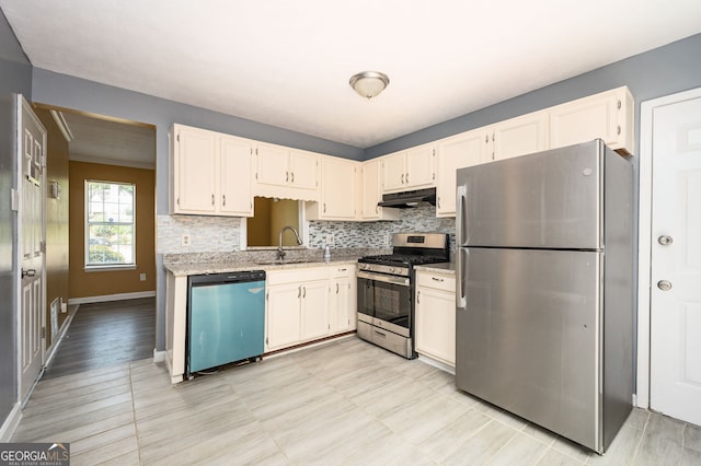 kitchen with stainless steel appliances, white cabinetry, backsplash, and sink