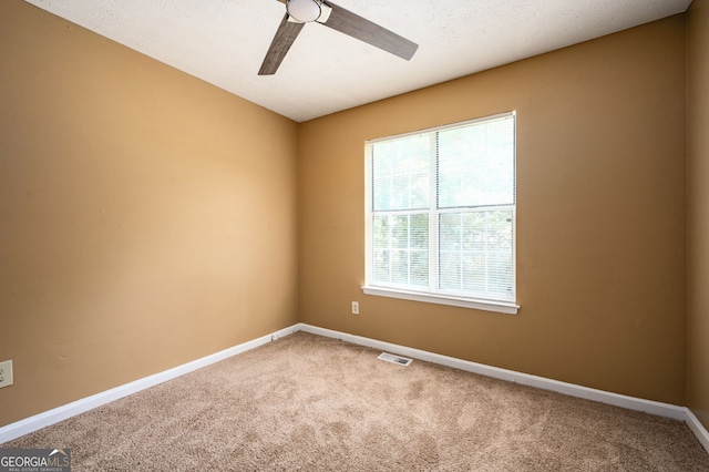 carpeted spare room with ceiling fan