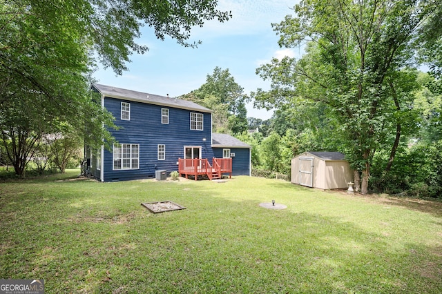 rear view of house with central AC, a deck, a storage unit, and a lawn