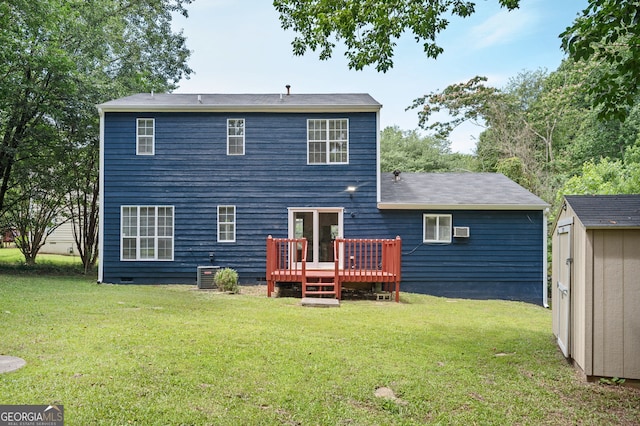 rear view of house with a lawn, a deck, cooling unit, and a shed